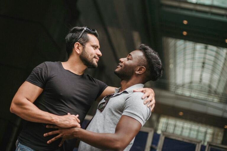 A tender moment shared between two men embracing indoors, reflecting deep affection and connection.